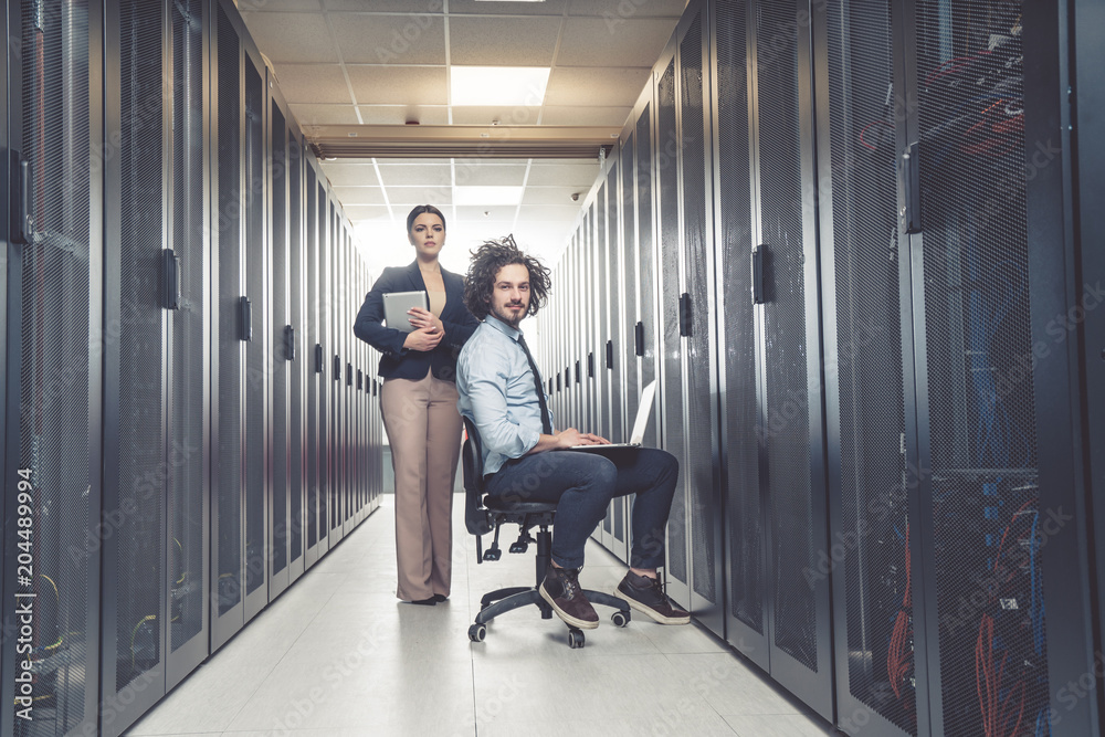 Fototapeta premium Man and woman working on servers at data center