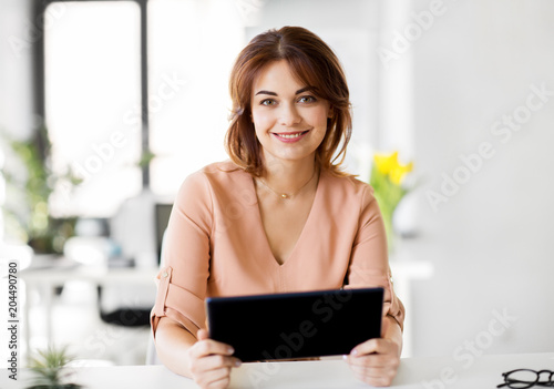 business, technology and people concept - smiling businesswoman with tablet pc computer working at office