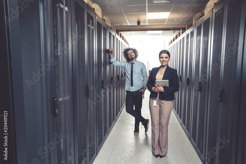 Man and woman working on servers at data center