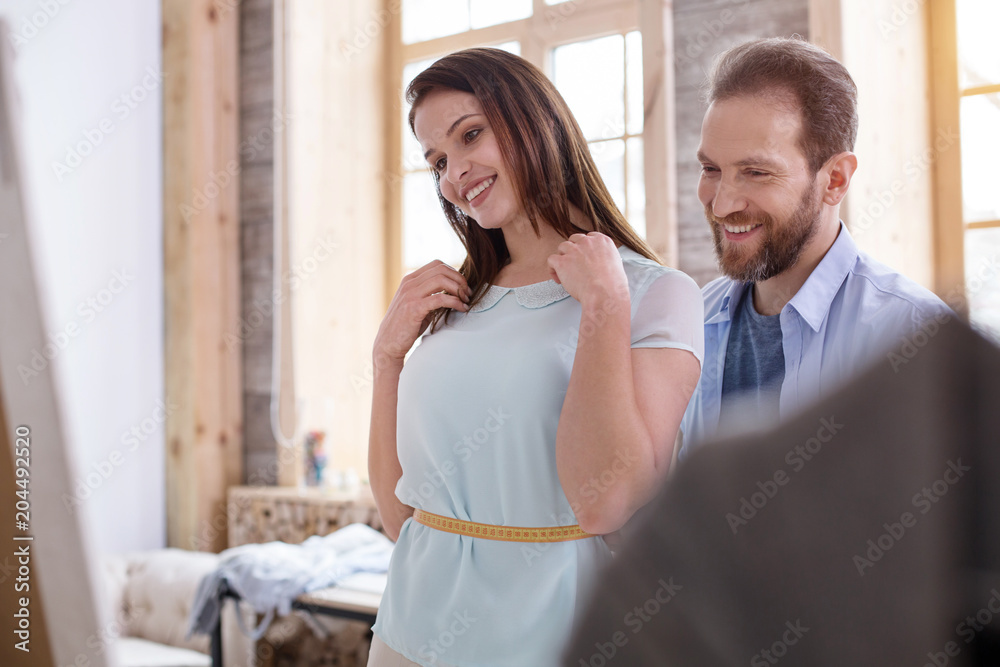 Obraz premium Required adjustment. Exuberant craftsman taking measurements while advising female customer