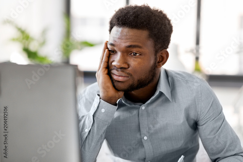 business, people, deadline and technology concept - stressed african american businessman with computer working at office