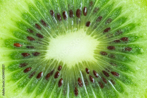 Fresh and juicy kiwi fruit with cross section cut in close up view macro concept to present pattern and texture for background. Kiwi have sweet and sour taste have high vitamin c and antioxidant.