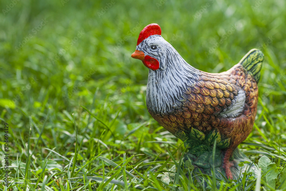 Decorative porcelain chicken on the green grass
