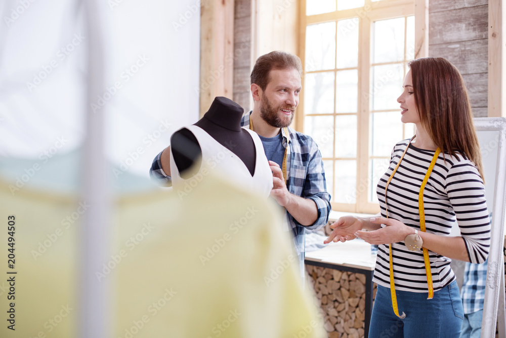 Obraz premium Love at work. Positive couple tailors chatting and modifying dress