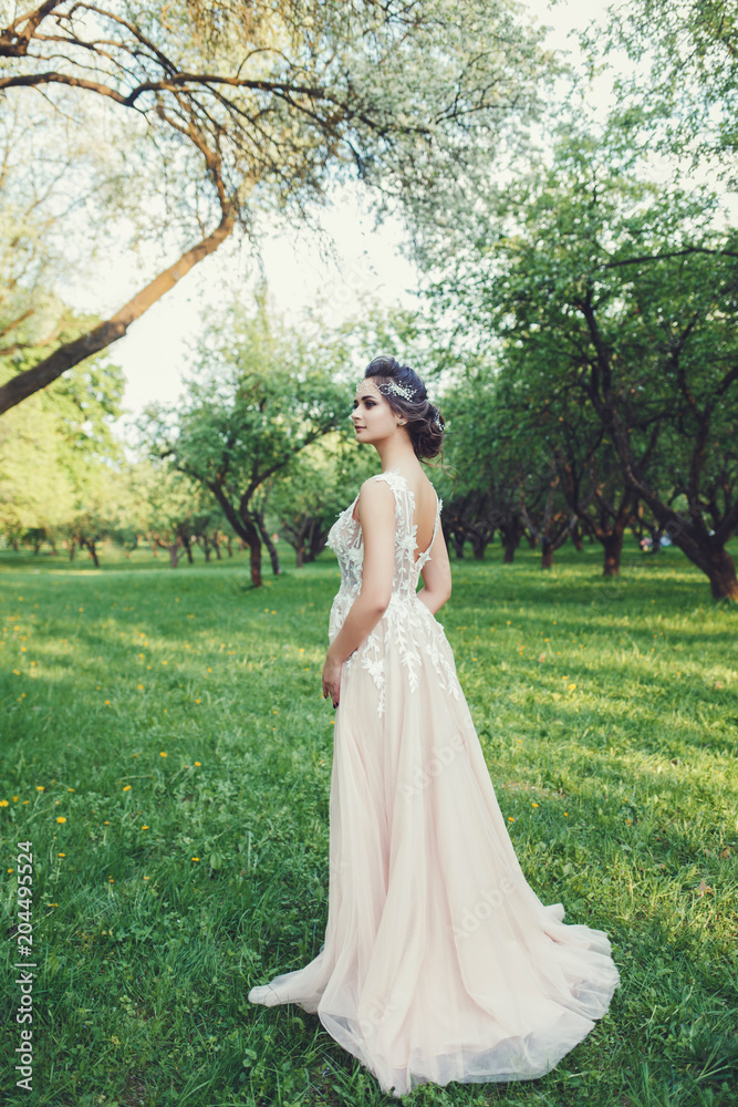 Beautiful bride in fashion wedding dress on natural background. Wedding day.