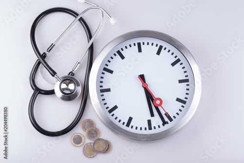 Stethoskop in der Arztpraxis mit einer Uhr und Geld © HNFOTO