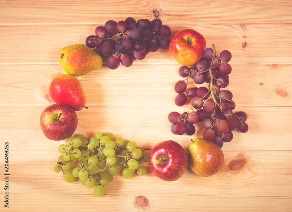 Fresh fruits frame on wooden background Fresh fruits frame on wooden background