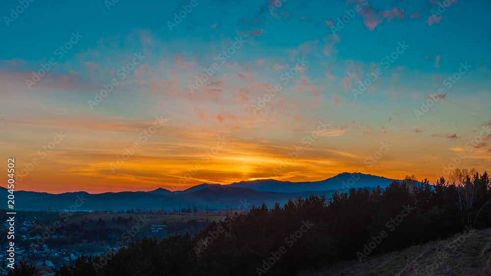 Panorama of the setting sun on the mountains in the summer. Gorno-Altaisk.