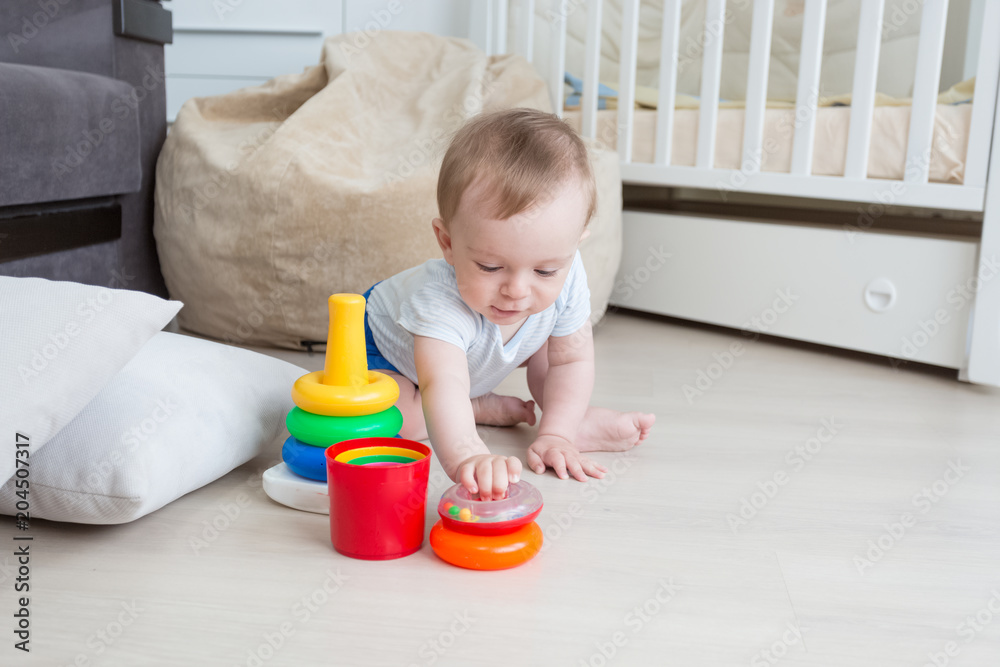 Adorable 10 months old toddler boy p laying in educaitonal games on floor Adorable 10 months old toddler boy p laying in educaitonal games on floor