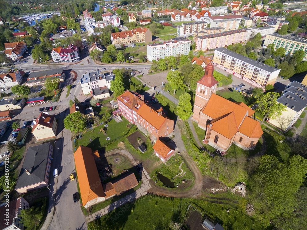 Aerial view of Wegorzewo town, Poland (former Angerburg, East Prussia). Gothic style St. Peter and St. Paul's Church on the right