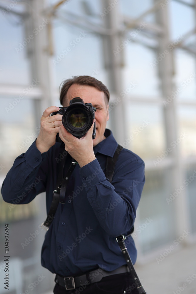 Work of the photographer. A man looks at the camera lens. Journalist. Work of the photographer. A man looks at the camera lens. Journalist.