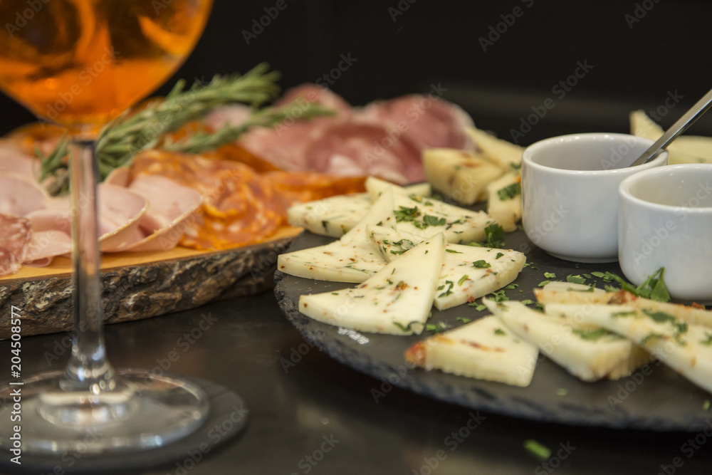Traditional italian aperitif with proscioutto, mortadella sausage, cheese and aperol spritz drink