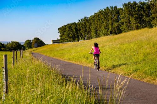 A cyclist rides along the dike in the sunlight © Matthias