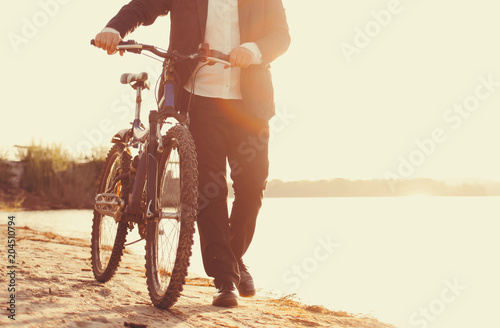 Businessman with a bicycle on the beach