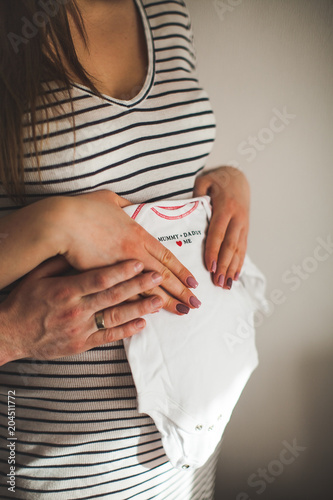 pregnant woman holding hands with her belly