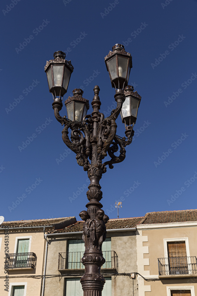Farola con esculturas y cuatro lámparas.
