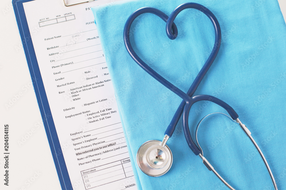 A stethoscope shaping a heart on a medical uniform, closeup, selective focus A stethoscope shaping a heart on a medical uniform, closeup, selective focus