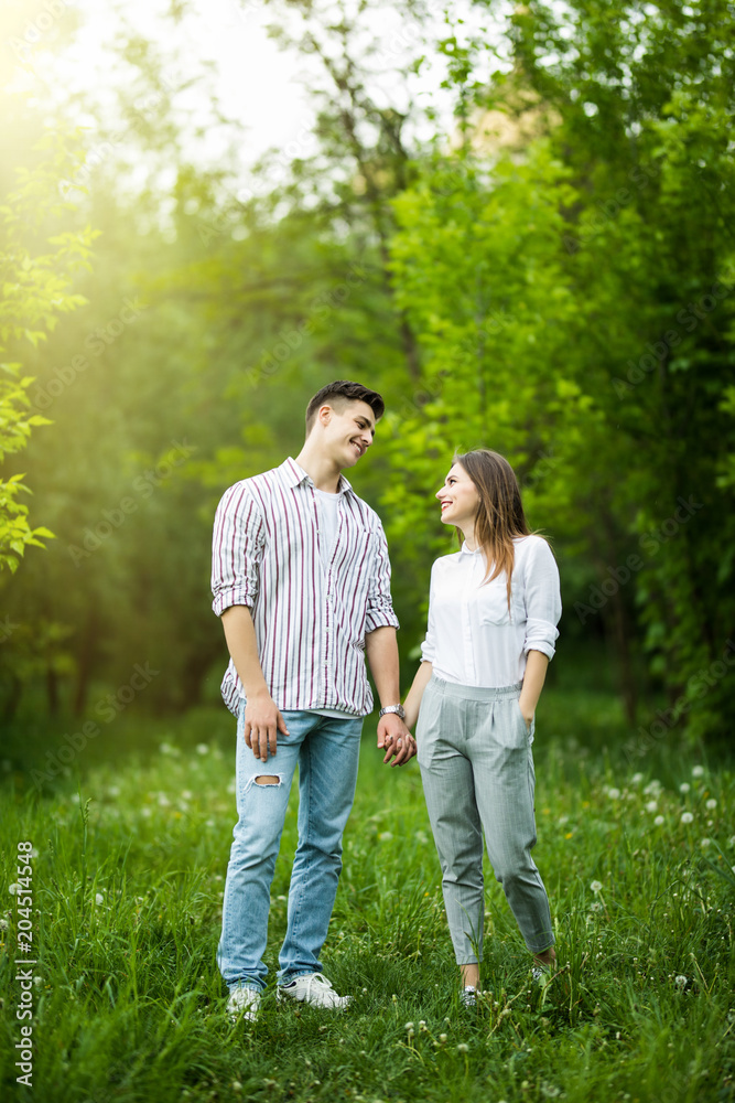 Portrait of a happy couple walking together outdoors in green park Portrait of a happy couple walking together outdoors in green park