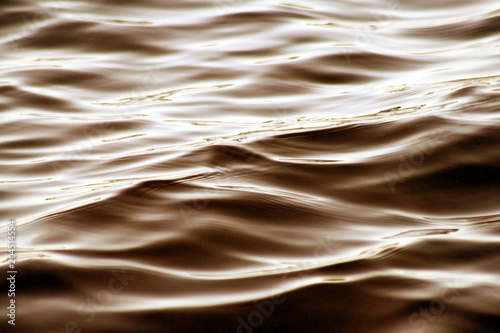 Soft ripples moving along the surface of beautiful bronze colored waters 