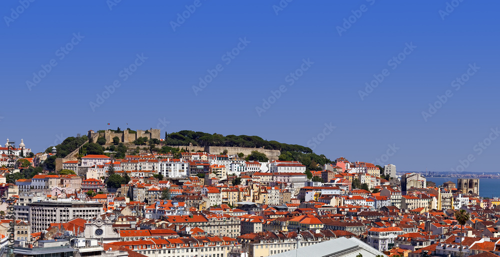Lisbon, Portugal. View of the Castelo de Sao Jorge Castle aka Saint or St. George Castle, the Baixa, Alfama and Mouraria Districts. Typical Portuguese orange rooftops.