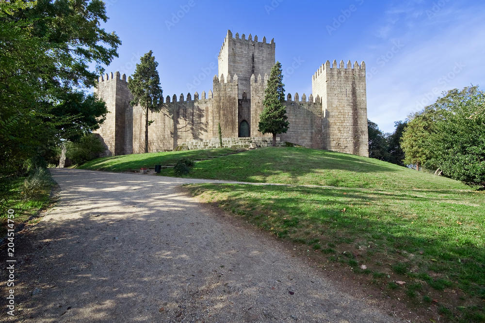 Naklejka premium Castelo de Guimaraes Castle. Most famous castle in Portugal. Birth place of the first Portuguese King and the Portuguese nation. Guimaraes, Portugal.