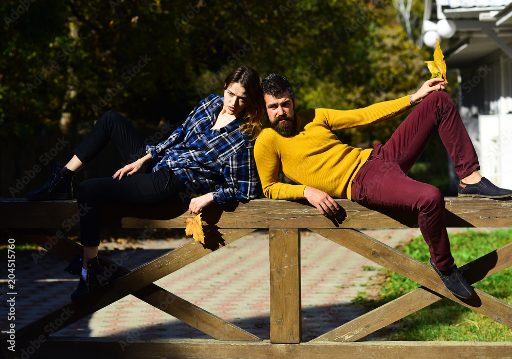 Girl and bearded guy lie on handrail back to back. Girl and bearded guy lie on handrail back to back.