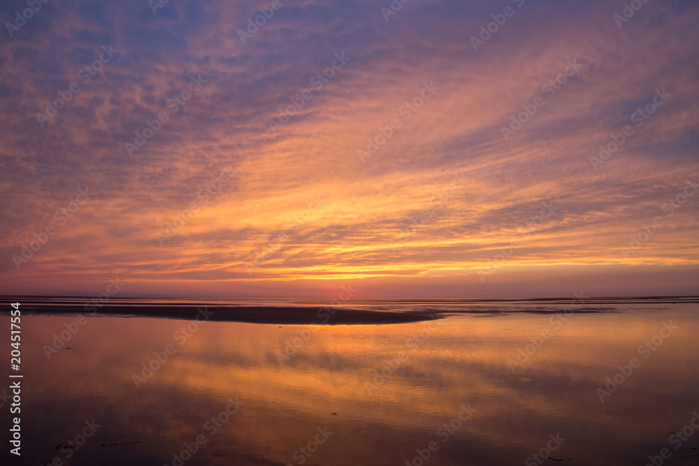 Obraz premium Beach sunset with soft sky and clouds