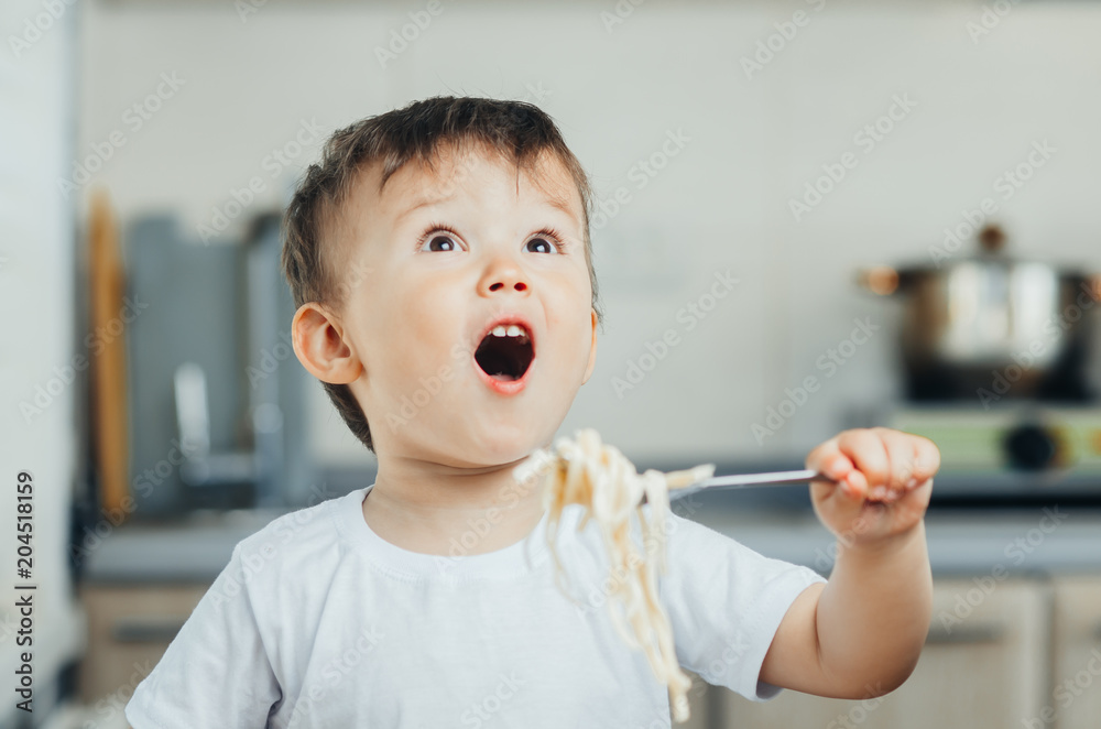 the child eats pasta with a fork and shouts rejoices very much the child eats pasta with a fork and shouts rejoices very much