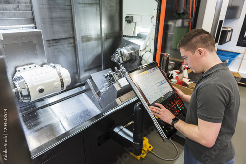 Man operating machine in factory photo