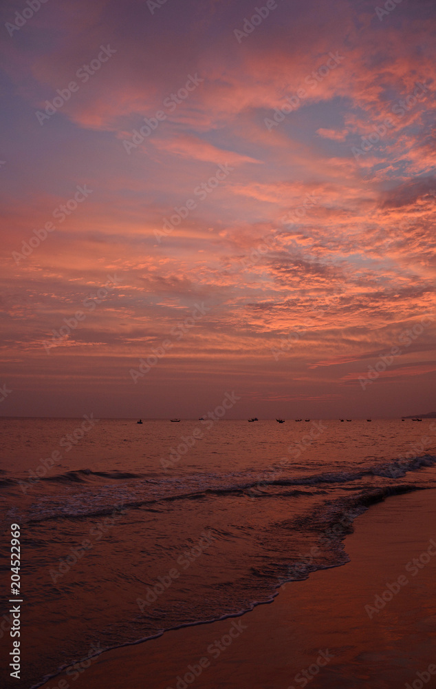 Sunset over the water off the coast of the beach at Mui Ne in central south Binh Thuan Province, Vietnam
