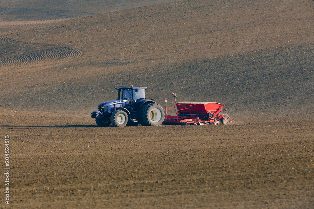 Fototapeta premium tractor with seed drill on field