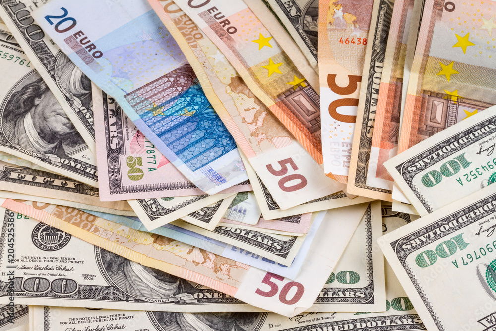 Business abstract background - banknotes of dollars and euros close-up, scattered on flat surface, different denominations