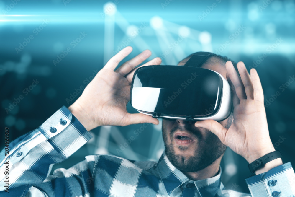 A young man with a beard in glasses of virtual reality on a technological background A young man with a beard in glasses of virtual reality on a technological background