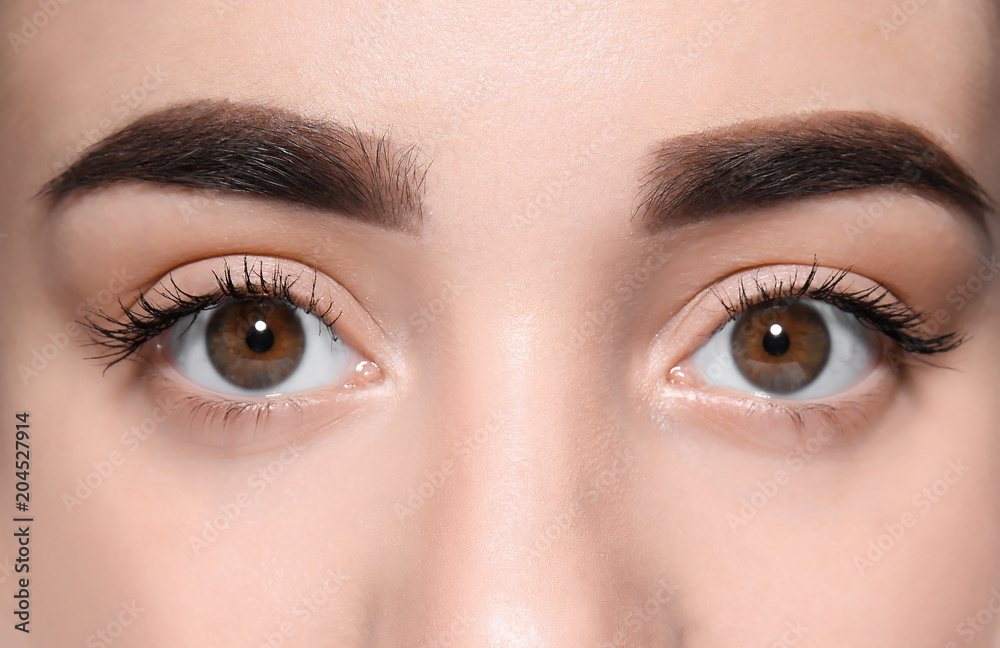 Beautiful woman with perfect eyebrows on grey background, closeup