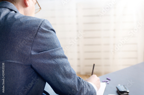 Man writing down measurement results from glucometer after blood test