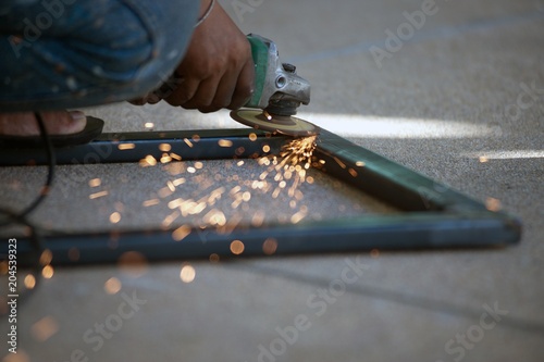 The worker is welding metal part of table steel in factory. photo