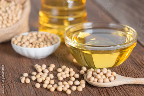 Soybean oil and Soybean on wooden table.