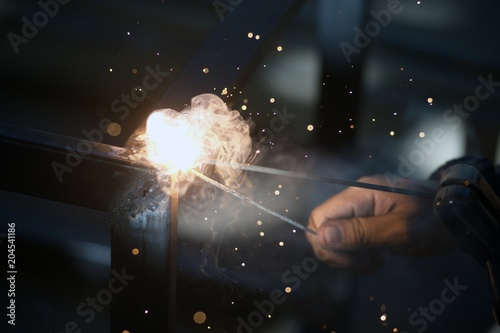 Worker is welding sparks table steel in factory. © topten22photo