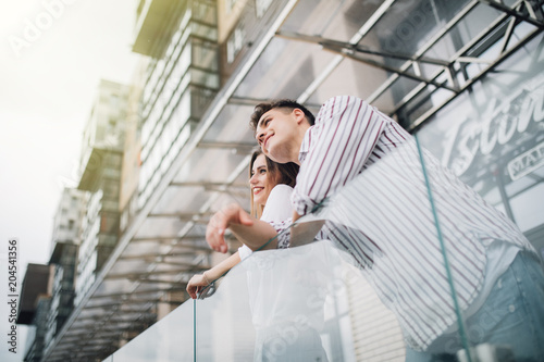 Принти на полотні Young in love couple standing on terrace of their new modern building outdoors