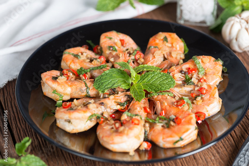 Stir-fried Shrimp with pepper and garlic on black plate.