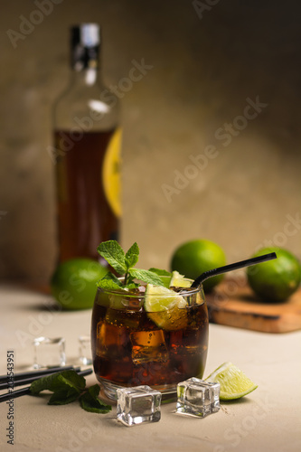 Фотография Cuba Libre drink with mint leaves and pieces of lime.