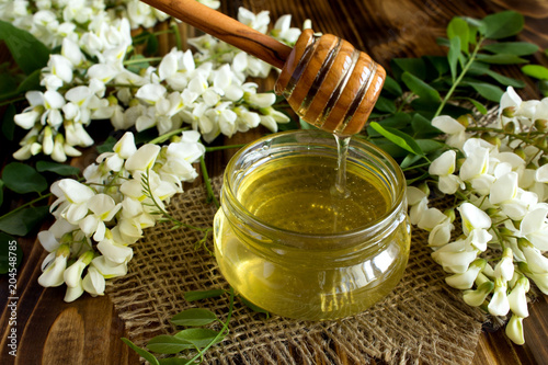 Honey and acacia flowers on the  rustic wooden background photo