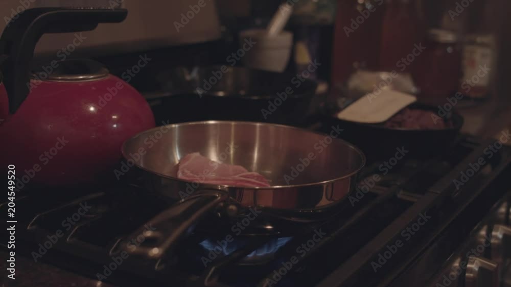 Dropping a pork chop onto a hot pan with oil, creating a splash. Dropping a pork chop onto a hot pan with oil, creating a splash.