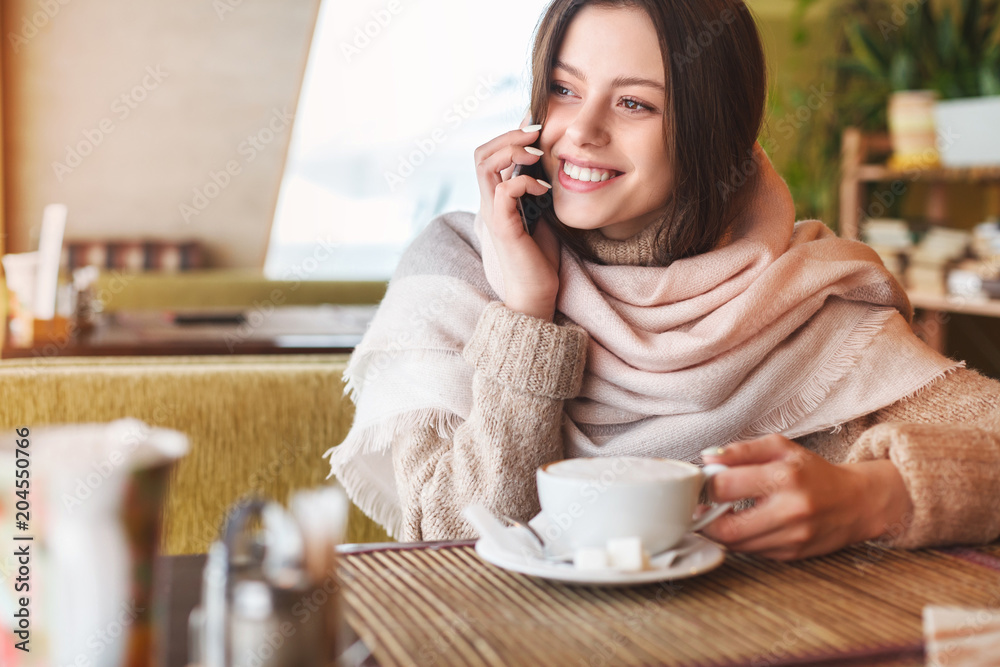 Beautiful young girl using phone in cafe Beautiful young girl using phone in cafe