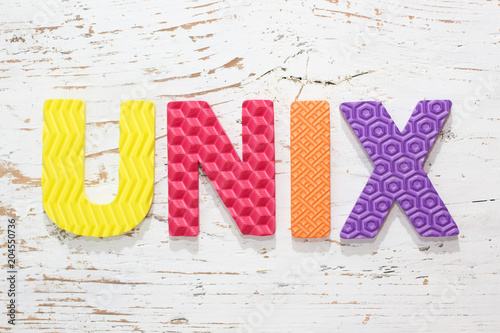 Word UNIX from colorful rubber alphabet letters on wooden board background. photo