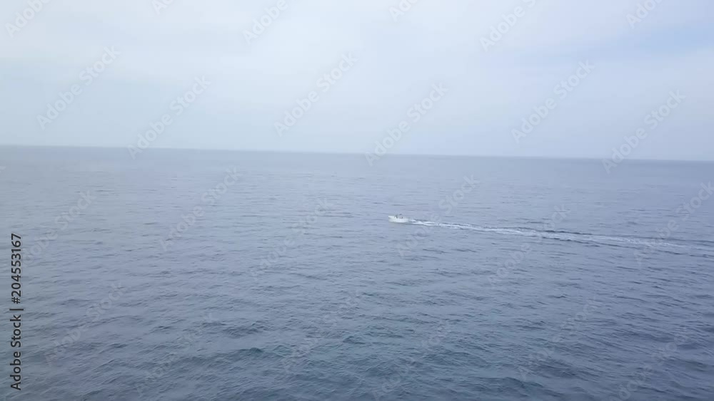 Aerial of a fast luxury speed boat racing in blue sea waters Aerial of a fast luxury speed boat racing in blue sea waters