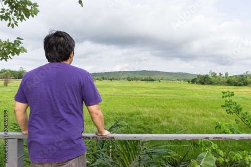 Landscape of green forest with back of asian man tourist traveller in the mountain, Khonkean Thailand. photo