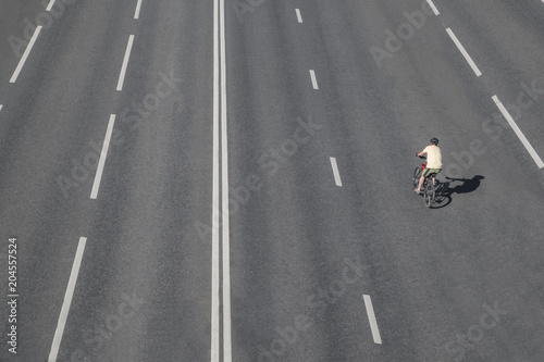 one bicyclist man rides on an empty road in moscow,russia