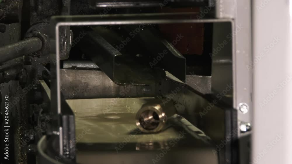 Automated machine manufacturing custom metal parts at industrial plant. Automated machine manufacturing custom metal parts at industrial plant.