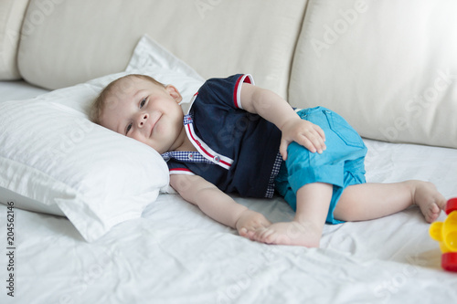 Cute smiling baby boy lying on bed and looking in camera © Кирилл Рыжов